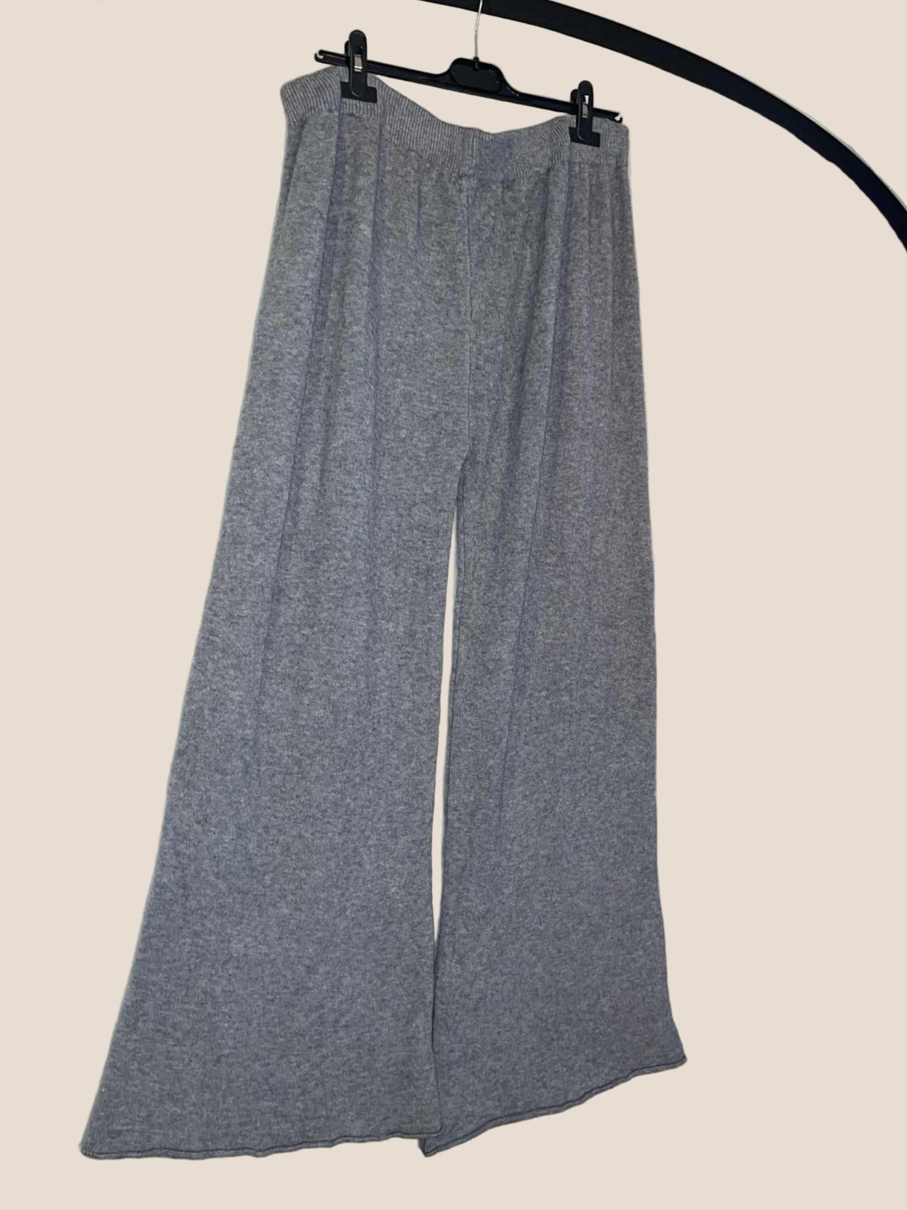 Gray pants on a hanger against a white background
