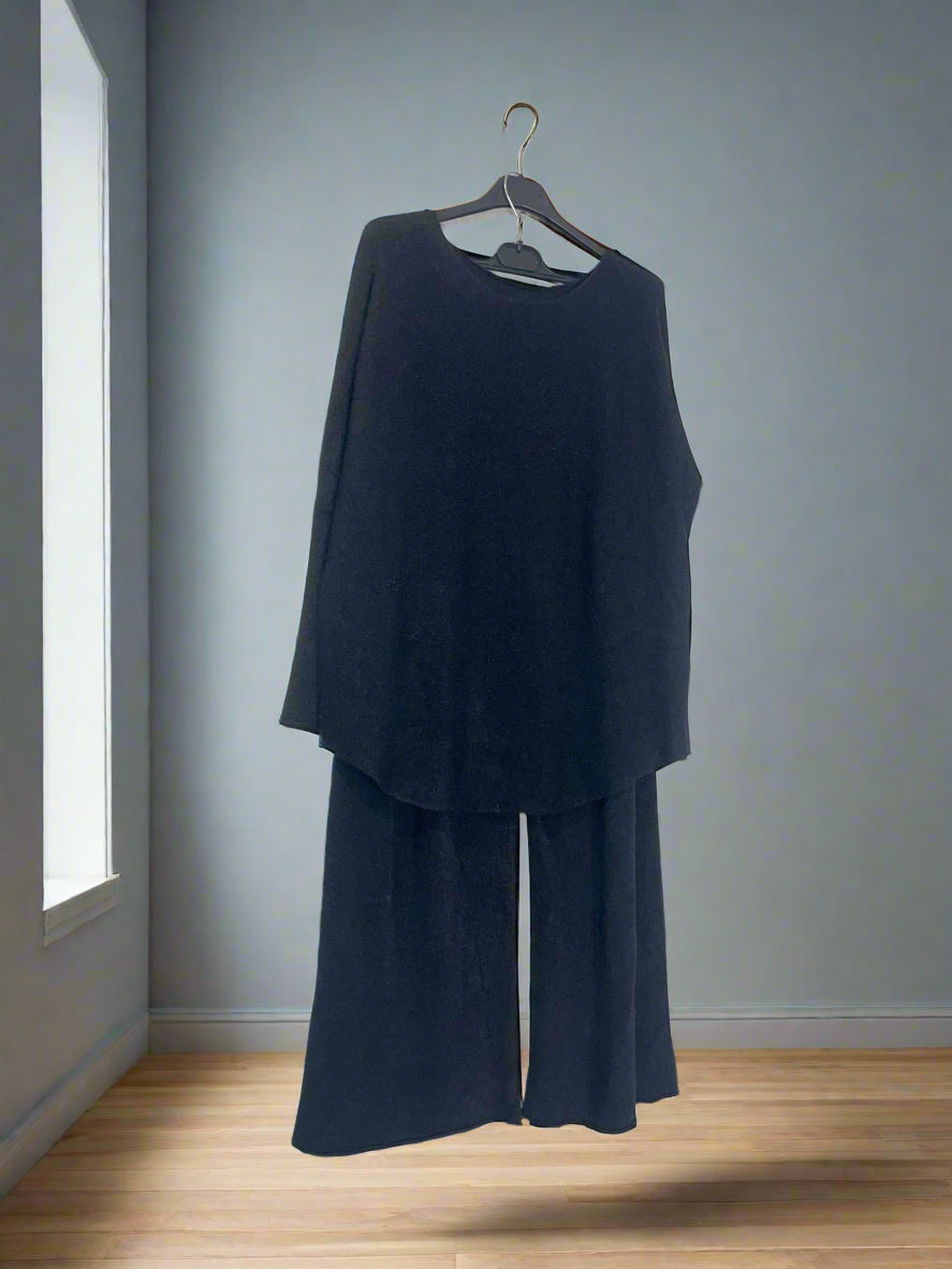 Black outfit on a hanger against a white wall