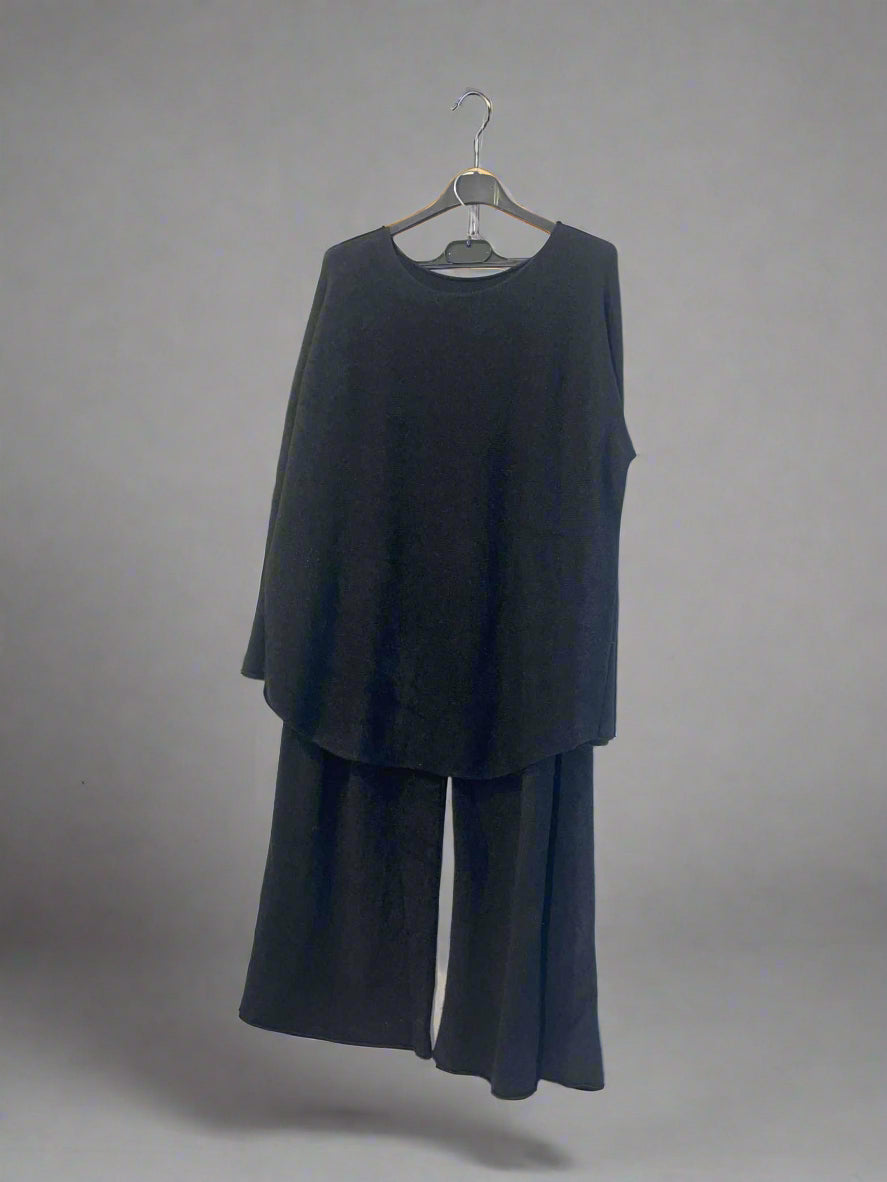 Black outfit on a hanger against a white background